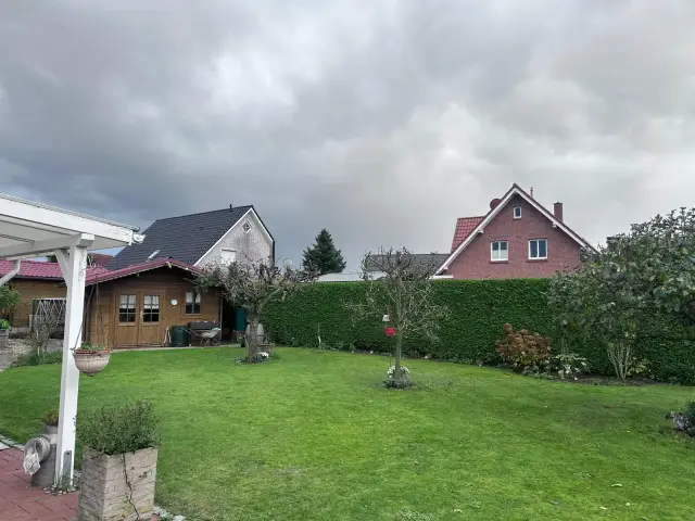 Gepflegter Garten mit geschnittener Hecke und Rasen