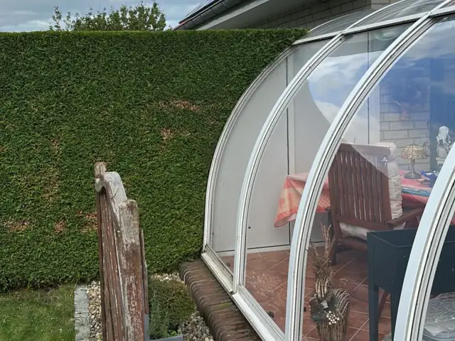 Geschnittene Hecke neben einer Terrassenüberdachung
